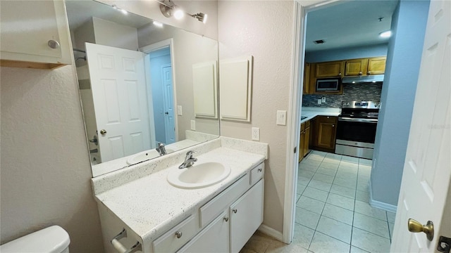 bathroom featuring tile patterned floors, decorative backsplash, toilet, and vanity