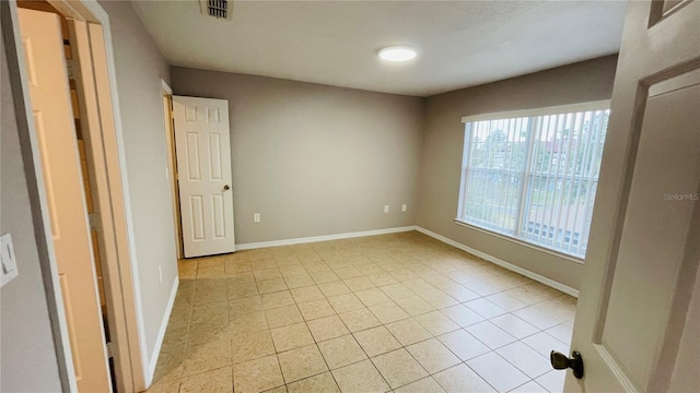 spare room featuring light tile patterned flooring