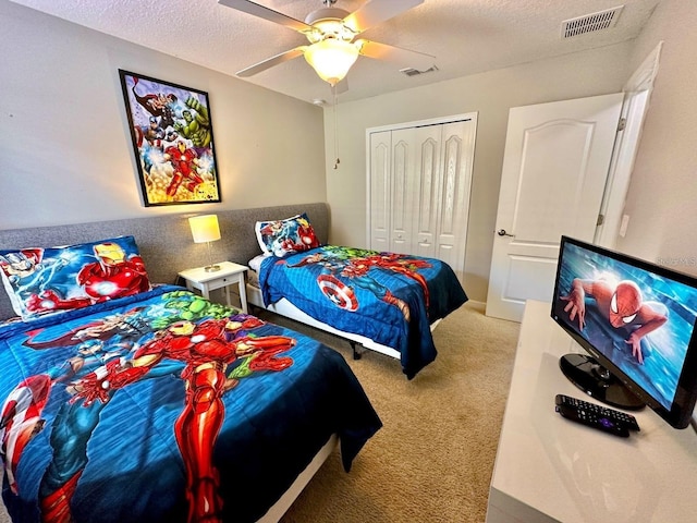 bedroom featuring carpet floors, a textured ceiling, ceiling fan, and a closet