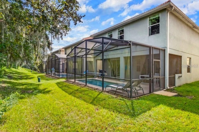 rear view of property with a lanai, a yard, and a patio area