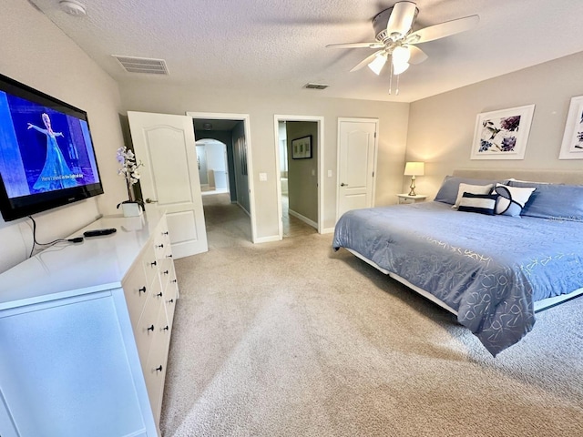 bedroom featuring light carpet, ceiling fan, and a textured ceiling