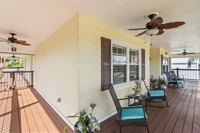 wooden terrace featuring a water view and a porch