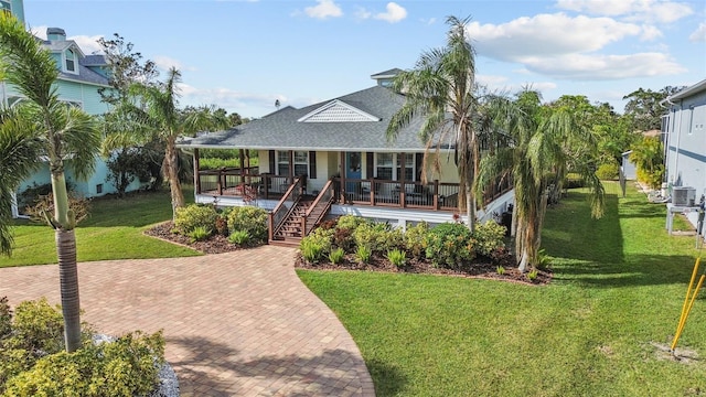 view of front of property featuring covered porch, central air condition unit, and a front lawn