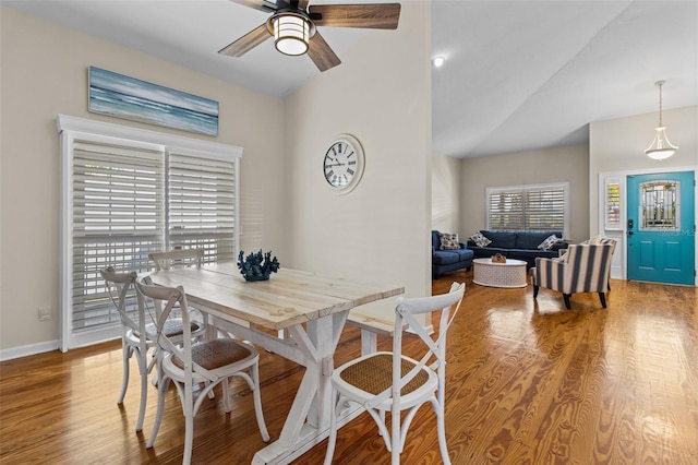 dining space featuring hardwood / wood-style flooring, ceiling fan, and vaulted ceiling