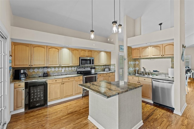 kitchen with light stone countertops, hanging light fixtures, stainless steel appliances, a high ceiling, and wine cooler