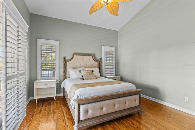 bedroom with ceiling fan, wood-type flooring, and vaulted ceiling