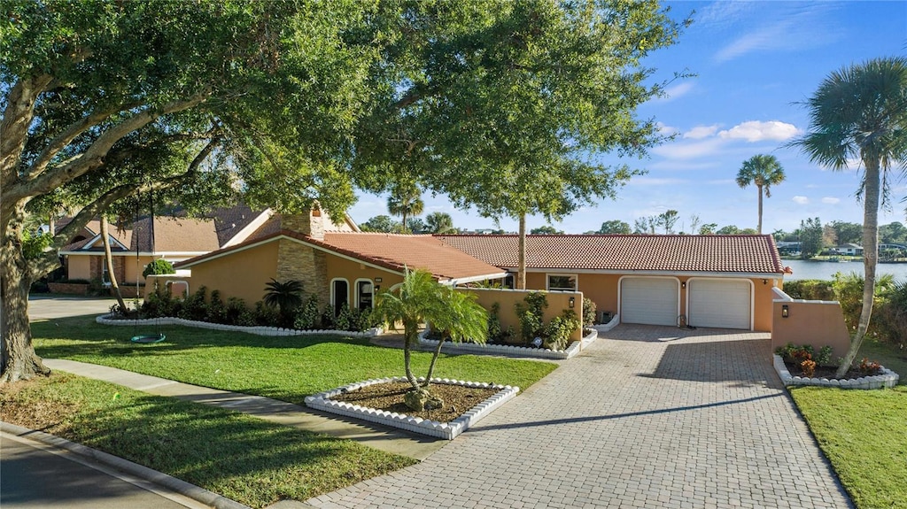 ranch-style home featuring a water view, a front yard, and a garage