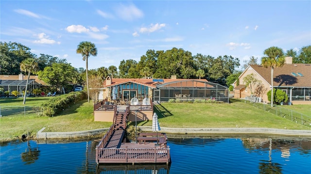 view of dock featuring a deck with water view, glass enclosure, and a lawn