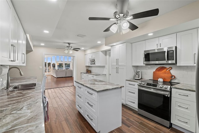 kitchen featuring light stone counters, white cabinetry, sink, and appliances with stainless steel finishes