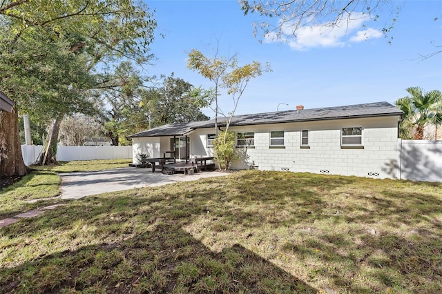 rear view of house with a yard and a patio