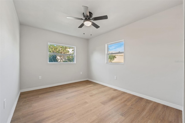 spare room featuring ceiling fan, a healthy amount of sunlight, and light wood-type flooring