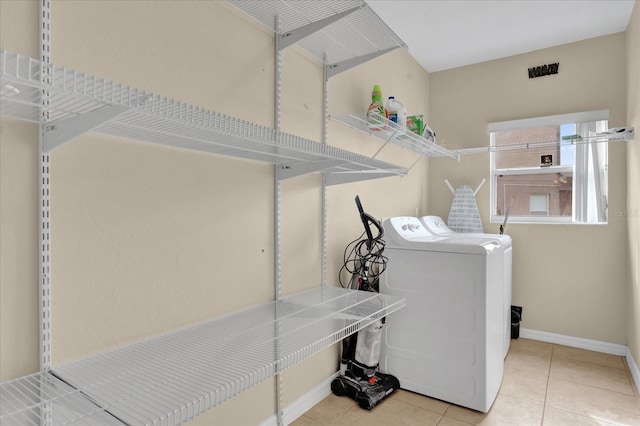 washroom featuring washing machine and clothes dryer and light tile patterned flooring