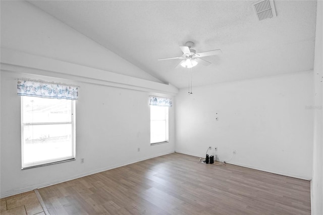 spare room with ceiling fan, vaulted ceiling, and hardwood / wood-style flooring