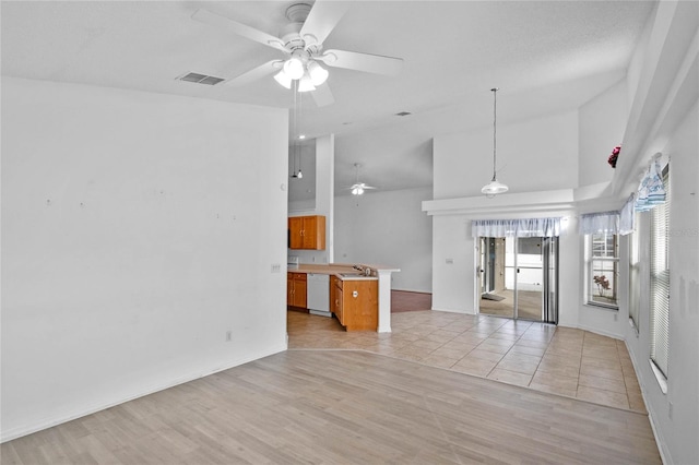 unfurnished living room featuring ceiling fan, light tile patterned floors, and a towering ceiling