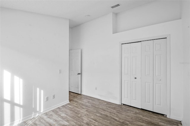 unfurnished bedroom with a closet and hardwood / wood-style floors