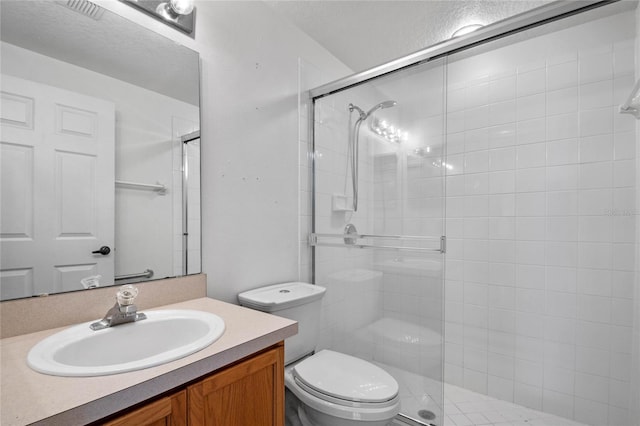 bathroom with a shower with shower door, toilet, and vanity