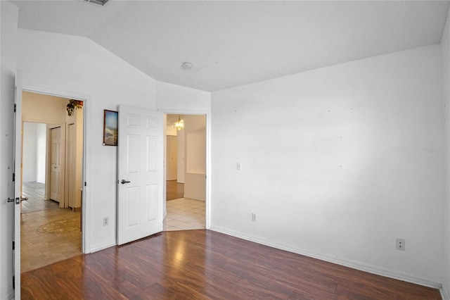 unfurnished room with lofted ceiling and hardwood / wood-style floors