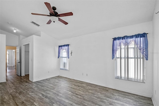 unfurnished room featuring lofted ceiling, ceiling fan, plenty of natural light, and wood-type flooring