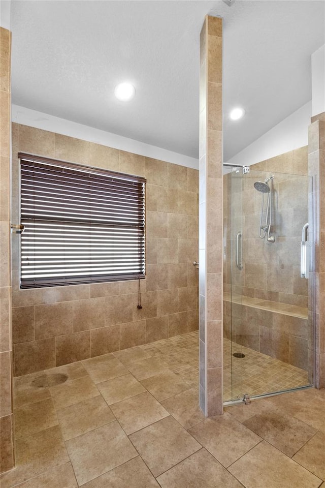 bathroom featuring an enclosed shower, vaulted ceiling, and tile patterned floors