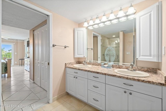 bathroom with tile patterned flooring, vanity, and a shower with shower door