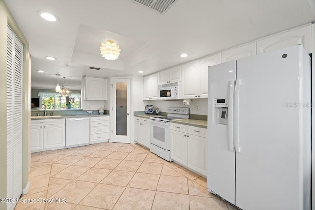 kitchen with pendant lighting, white appliances, a raised ceiling, light tile patterned floors, and white cabinetry