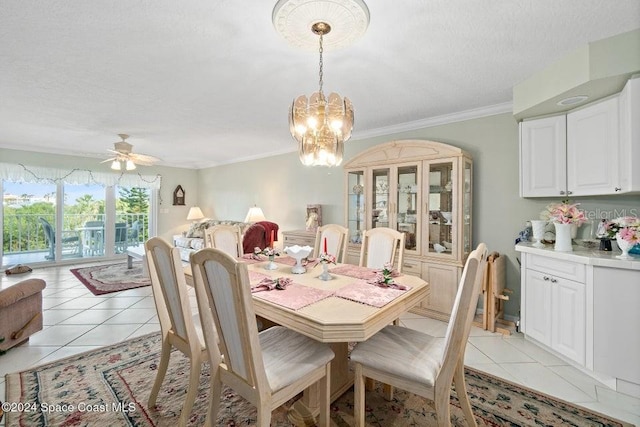 dining space featuring ceiling fan with notable chandelier, ornamental molding, a textured ceiling, and light tile patterned floors