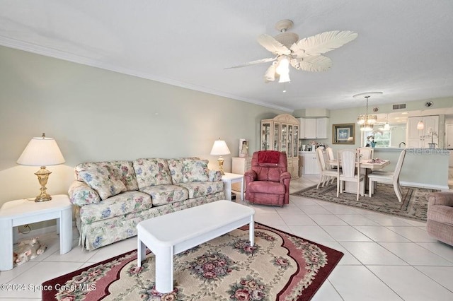 tiled living room with ceiling fan and crown molding