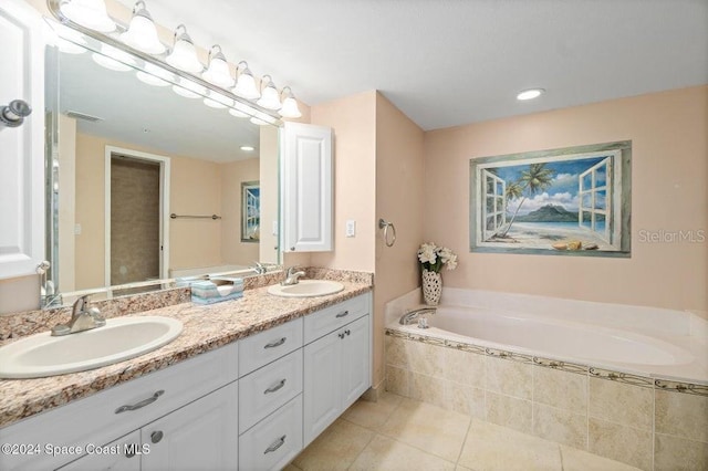 bathroom with tile patterned flooring, vanity, and a relaxing tiled tub