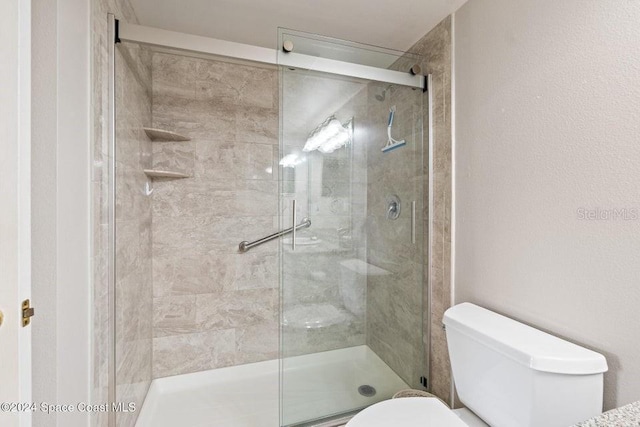 bathroom featuring an enclosed shower and toilet