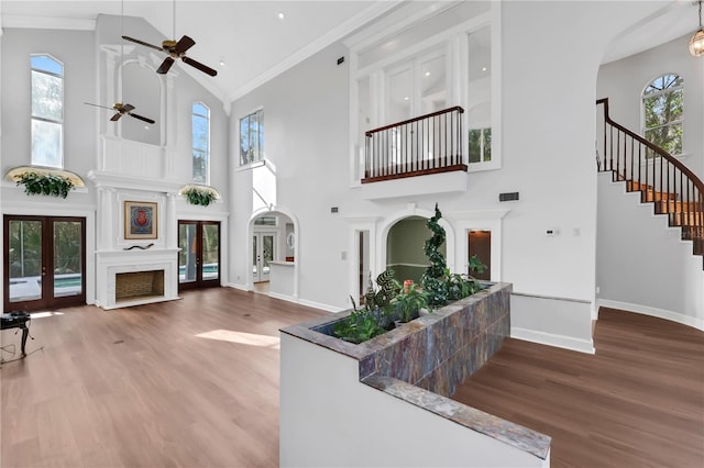 living room featuring a wealth of natural light, ornamental molding, high vaulted ceiling, and french doors