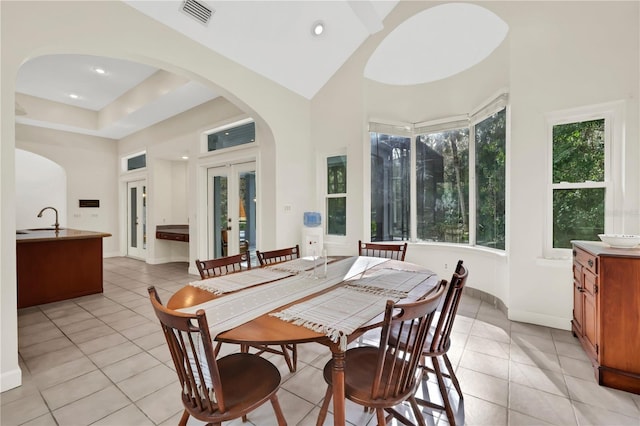 tiled dining area featuring a wealth of natural light, french doors, and sink