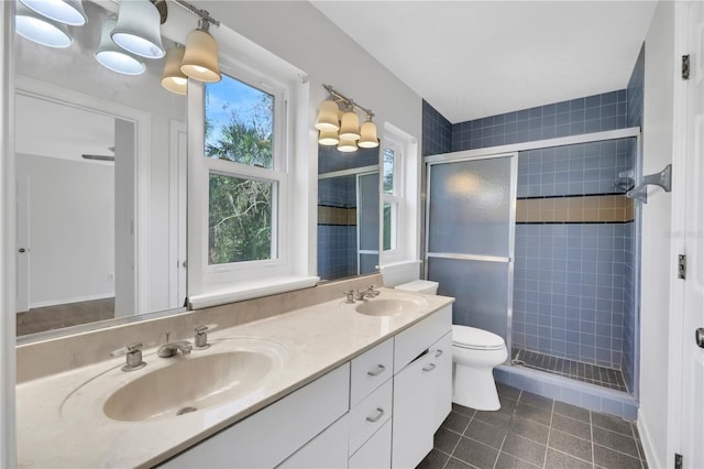 bathroom featuring tile patterned flooring, vanity, toilet, and a shower with door