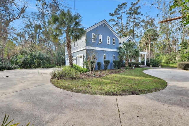 view of side of home featuring a garage and a yard