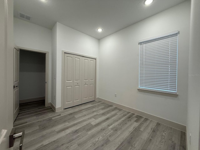 unfurnished bedroom featuring a closet and light wood-type flooring