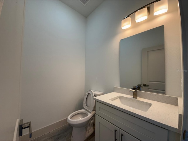 bathroom featuring vanity, wood-type flooring, and toilet