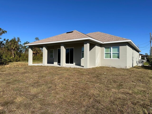 rear view of house featuring a yard