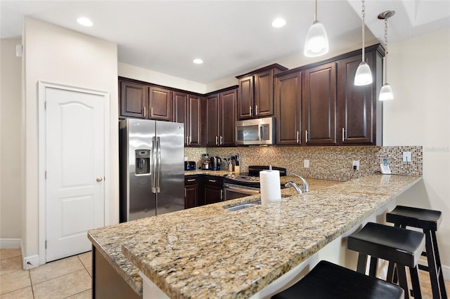 kitchen featuring stainless steel appliances, kitchen peninsula, decorative light fixtures, decorative backsplash, and light tile patterned flooring