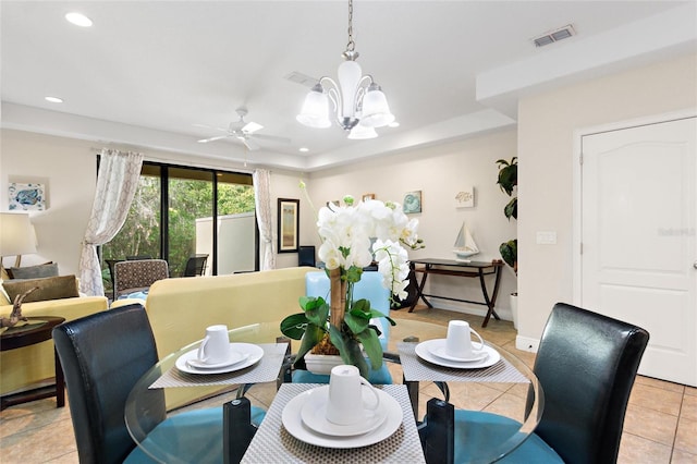 dining space with ceiling fan with notable chandelier and light tile patterned floors