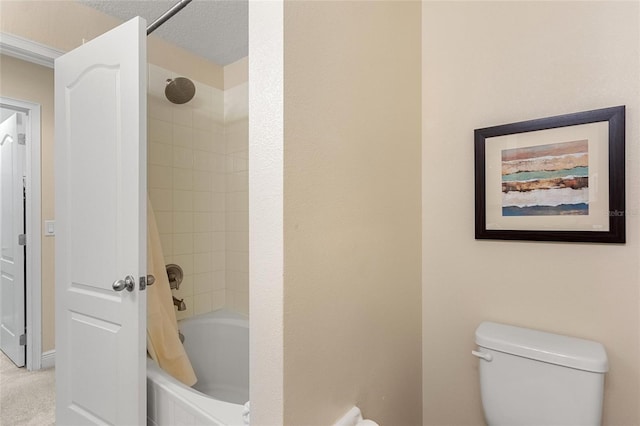 bathroom with a textured ceiling, toilet, and shower / tub combo with curtain