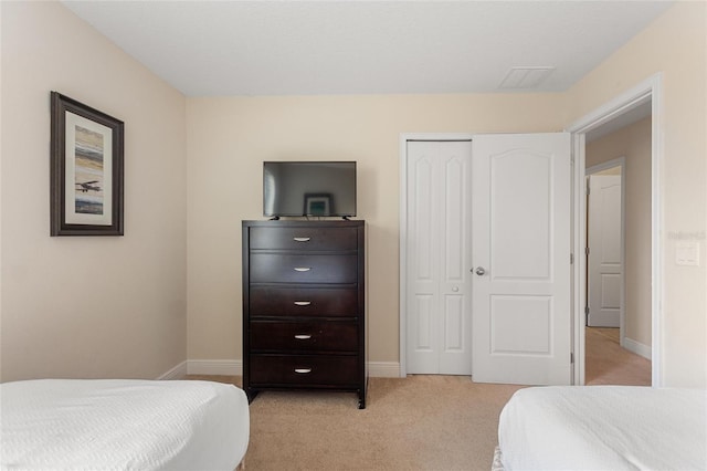 bedroom featuring a closet and light colored carpet