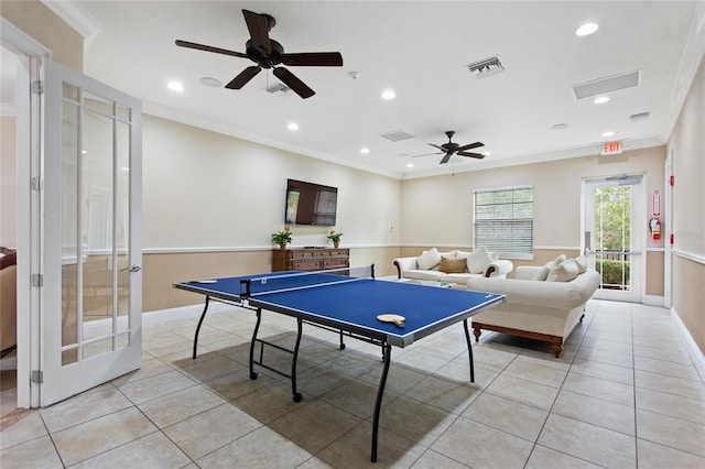 recreation room featuring light tile patterned floors, ceiling fan, and crown molding