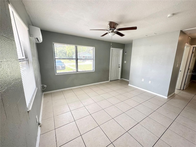 tiled spare room featuring a wall mounted air conditioner, a textured ceiling, and ceiling fan