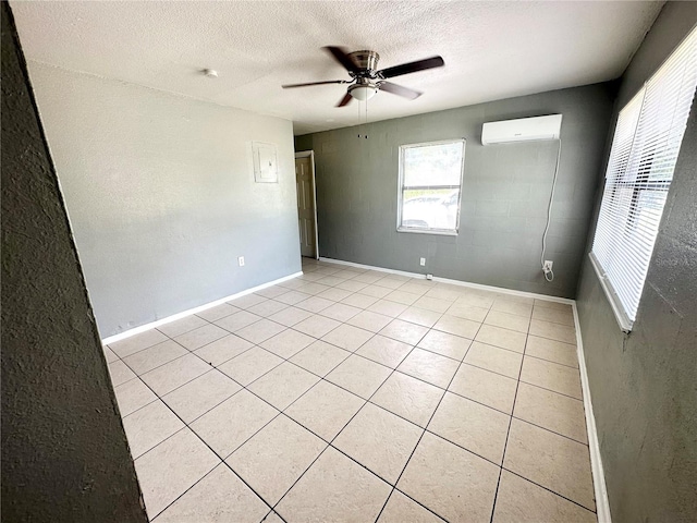 tiled spare room with a textured ceiling, ceiling fan, and a wall mounted air conditioner