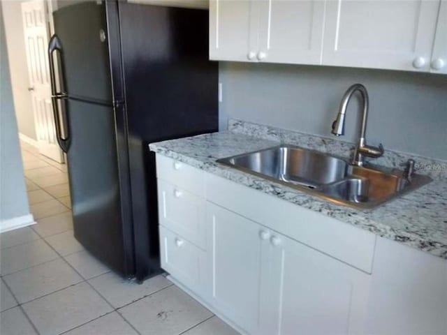 kitchen featuring white cabinetry, sink, and light tile patterned floors