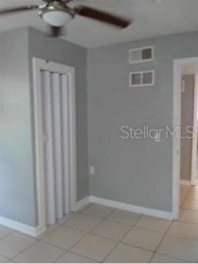 spare room featuring ceiling fan and light tile patterned floors