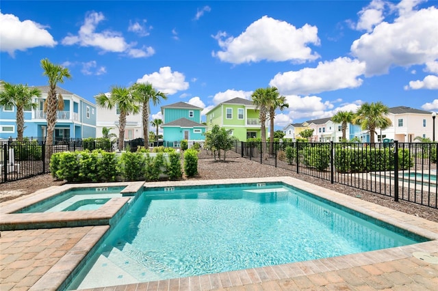 view of swimming pool with an in ground hot tub