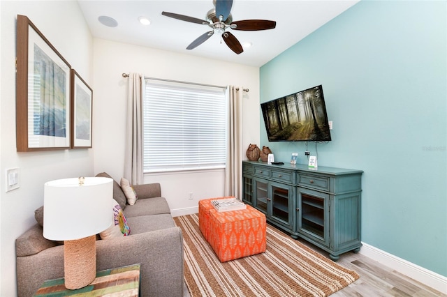 living room featuring light wood-type flooring and ceiling fan