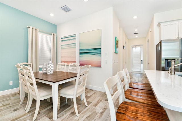 dining space with sink and light hardwood / wood-style flooring