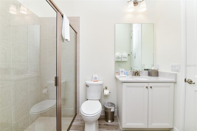 bathroom featuring vanity, toilet, and an enclosed shower