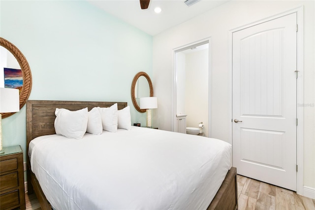 bedroom featuring ceiling fan, light hardwood / wood-style floors, and ensuite bath